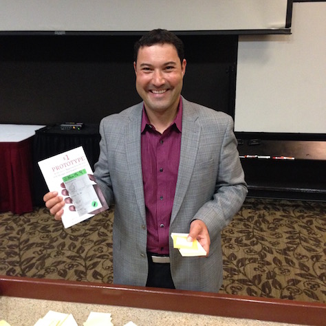 Greg Nudelman, holding his book $1 Prototype and a sticky-note smartphone